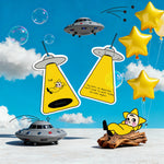 Shortcut Lab UFO-themed car fragrance cards in yellow with illustrated character and text ‘bye,’ styled in a playful scene with UFOs, star balloons, and blue sky background